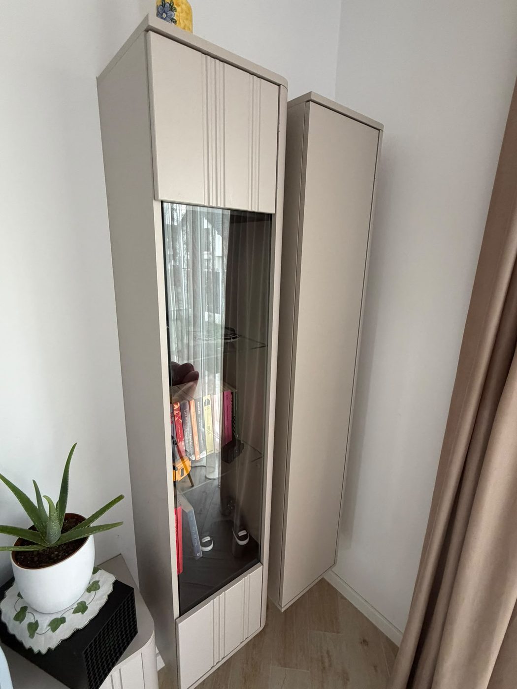 Vitrină și coloană de living aliniate și prinse în perete